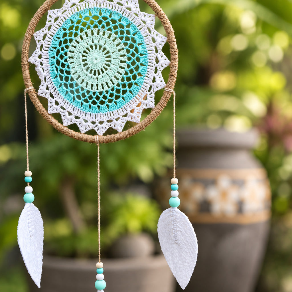 Turquoise dream catcher hanging in a garden with flower pots in the background – spiritual décor from CardsAmoreStore.